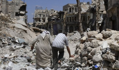 Two persons walk in the ruins of Aleppo, Syria