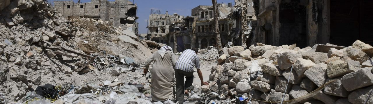 Two persons walk in the ruins of Aleppo, Syria