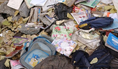 Children's clothes scattered amongst the debris of a collapsed building