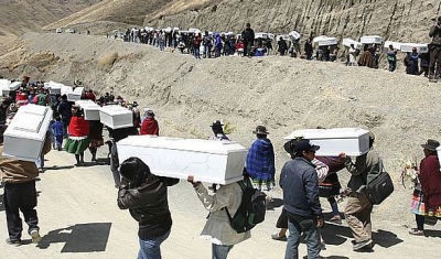 Group of people carrying coffins down the mountain