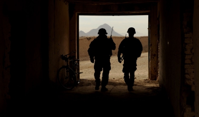 Two U.S. Soldiers walk out of a building