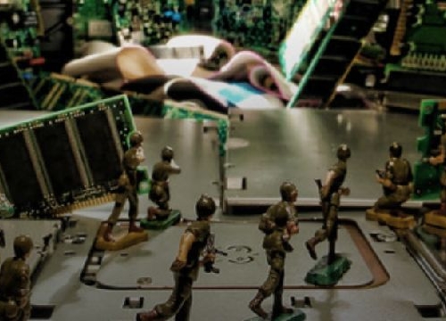 Toy soldiers siulating a fight in a context of electronic computer circuits