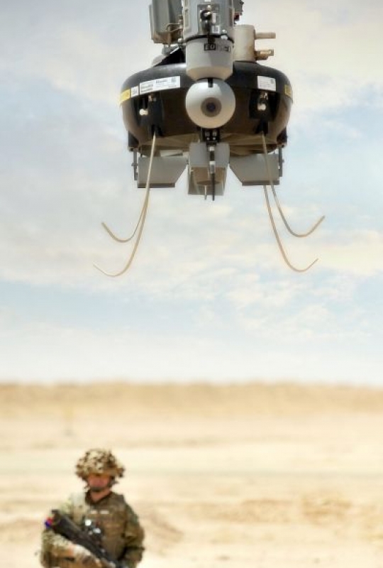 A soldier watches as a Tarantula Hawk (T-Hawk) Micro Remote Piloted Air System (RPAS) hovers over the desert in Afghanistan. 