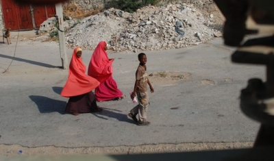 Women in bright headscarves walk along Mogadishu street