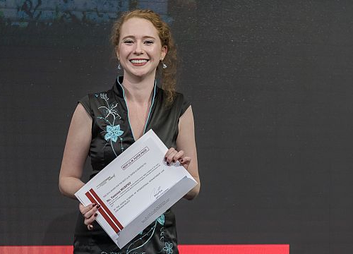 Picture of Vanessa Murphy with the Prize certificate of the LLM Best Paper Prize at the Graduation Ceremony